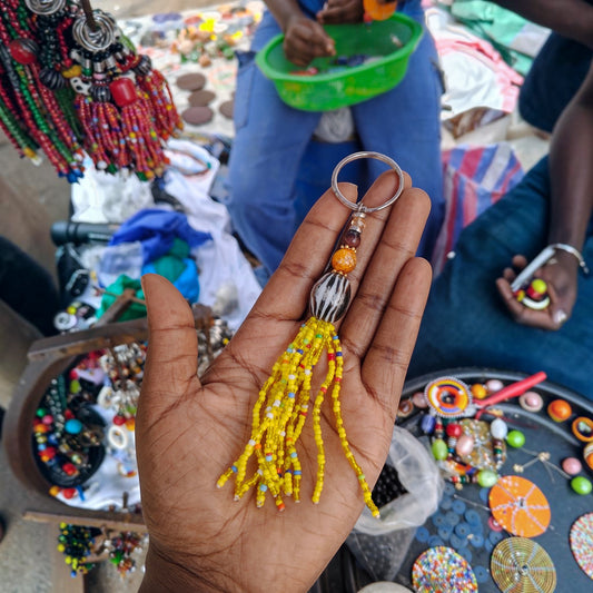 Handcrafted yellow beaded tassel keychain featuring a zebra striped focal bead made by Kibera artisans in Kenya