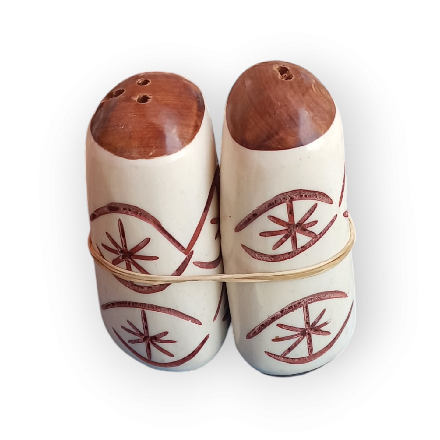 Unique handcrafted camel bone salt and pepper shakers from Kenya, featuring etched eye patterns and wooden tops, sold as a pair