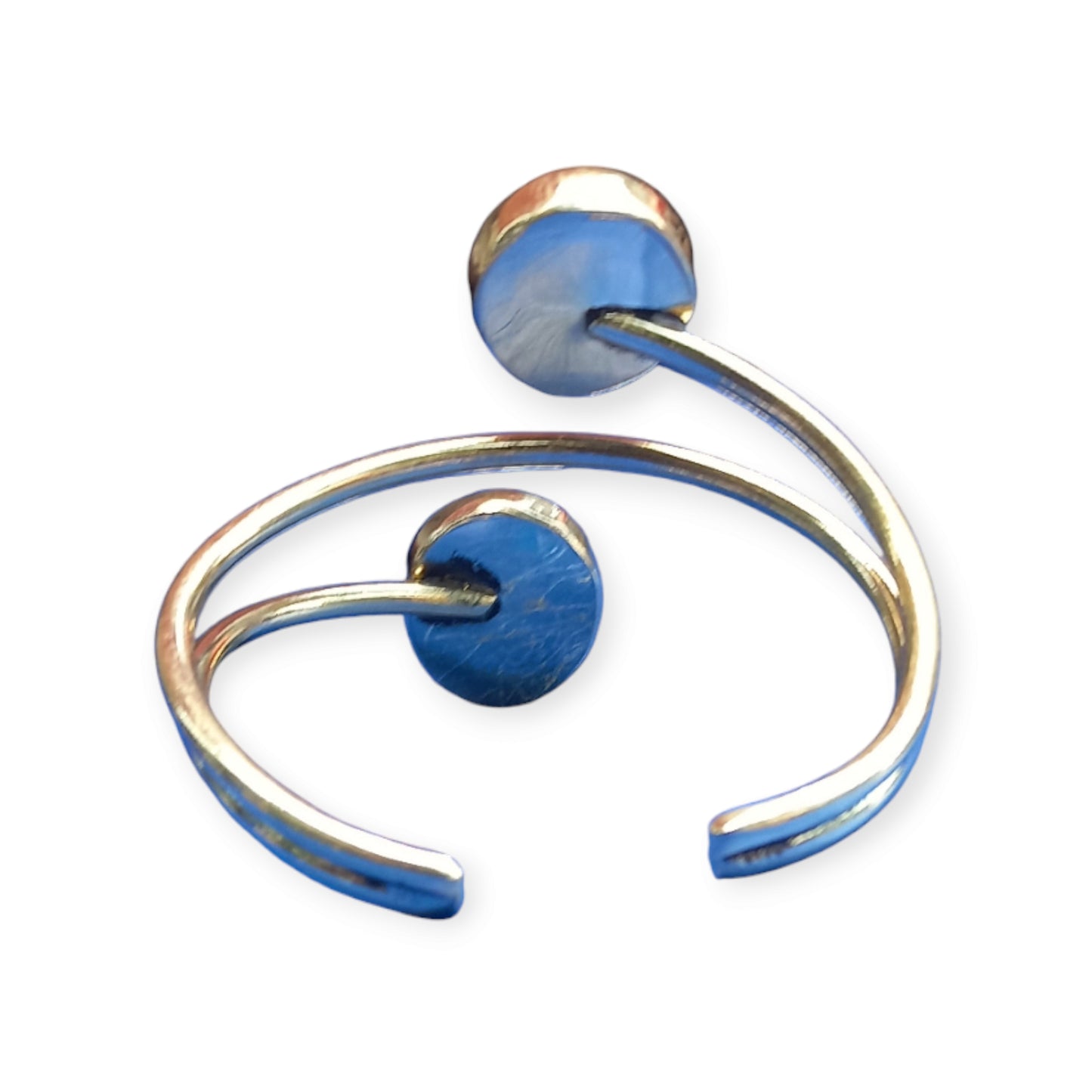 A stylish and adjustable bracelet crafted from brass in Kenya, designed as an open cuff and accented by two beautiful, round white beads.