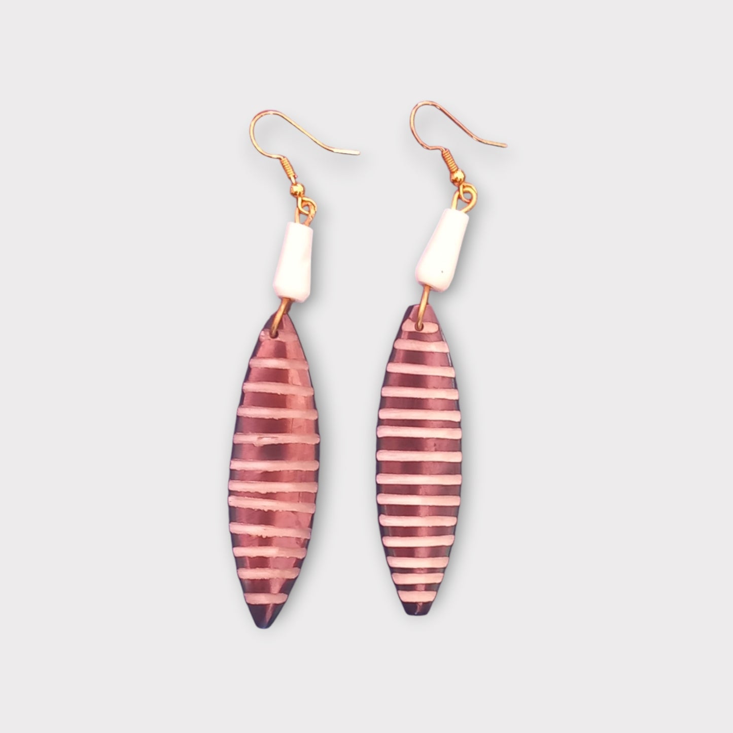 A pair of unique dangle earrings made in Kenya, featuring a minimalist, striped bone design.
Emphasizin