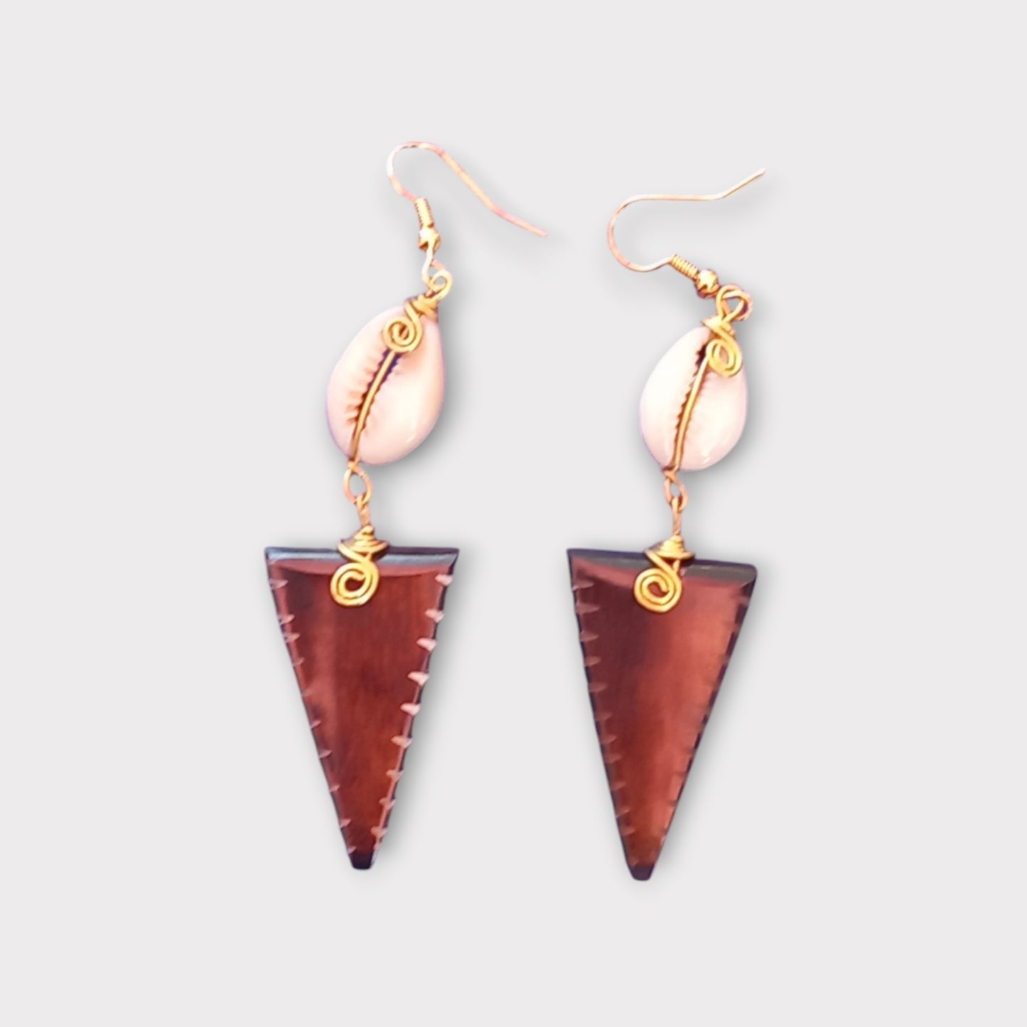 Kenyan earrings made of bone and cowrie shell, with a brown striped inverted triangular dangle and gold-toned wire accents.