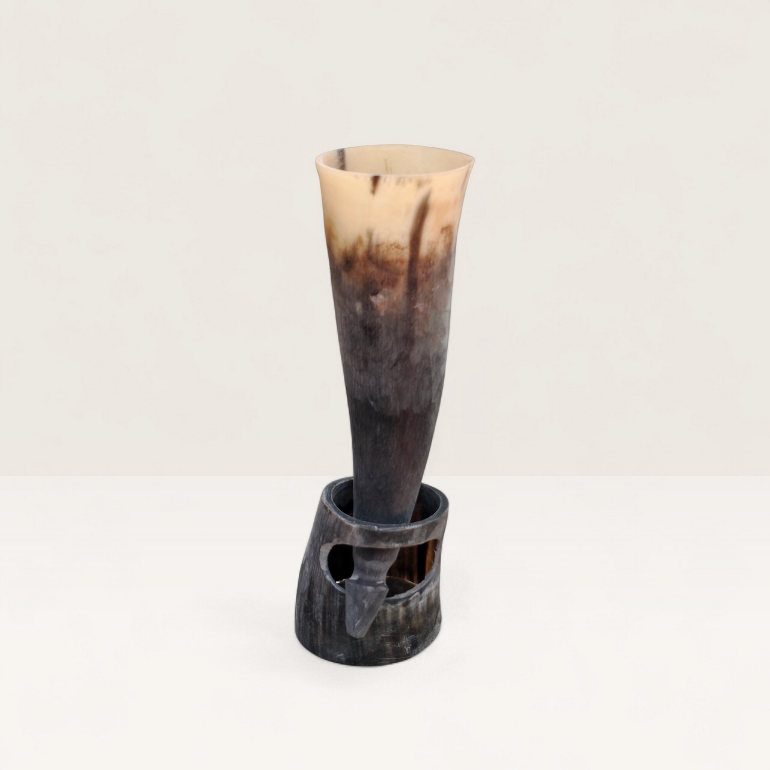 Handcrafted natural light cream and dark charcoal Kenyan cow horn Muratina drinking horn seated in its matching carved horn base, made in Kenya.