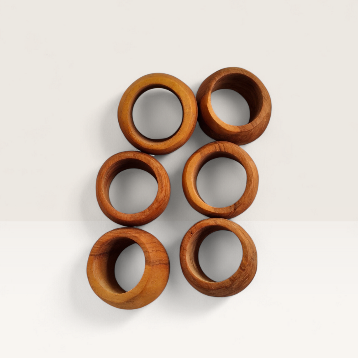 Handcrafted set of 6 Kenyan olive wood napkin rings showing rich natural grain texture, made in Ukambani Kenya.