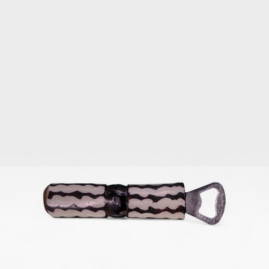 Handcrafted wavy batik cow bone bottle opener with black horizontal zigzag stripes made by Kibera artisans in Kenya