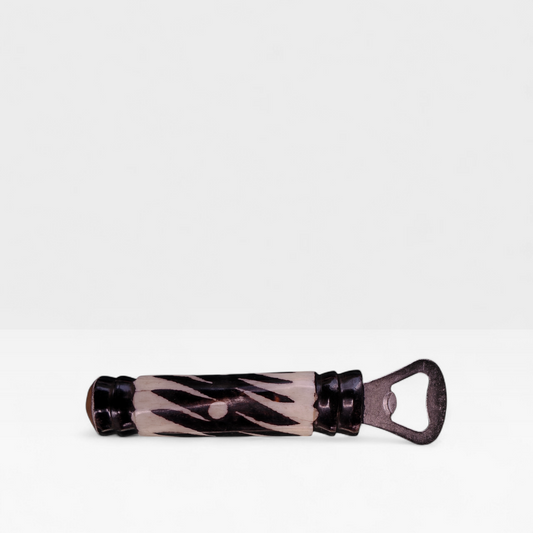 Handcrafted zebra batik cow bone bottle opener with black diagonal stripes made by Kibera artisans in Kenya