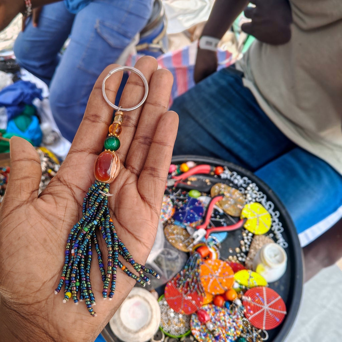 Handcrafted beaded tassel keychain featuring a carnelian agate swirl focal bead made by artisans in Kibera Kenya.