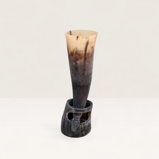 Handcrafted natural light cream and dark charcoal Kenyan cow horn Muratina drinking horn seated in its matching carved horn base, made in Kenya.