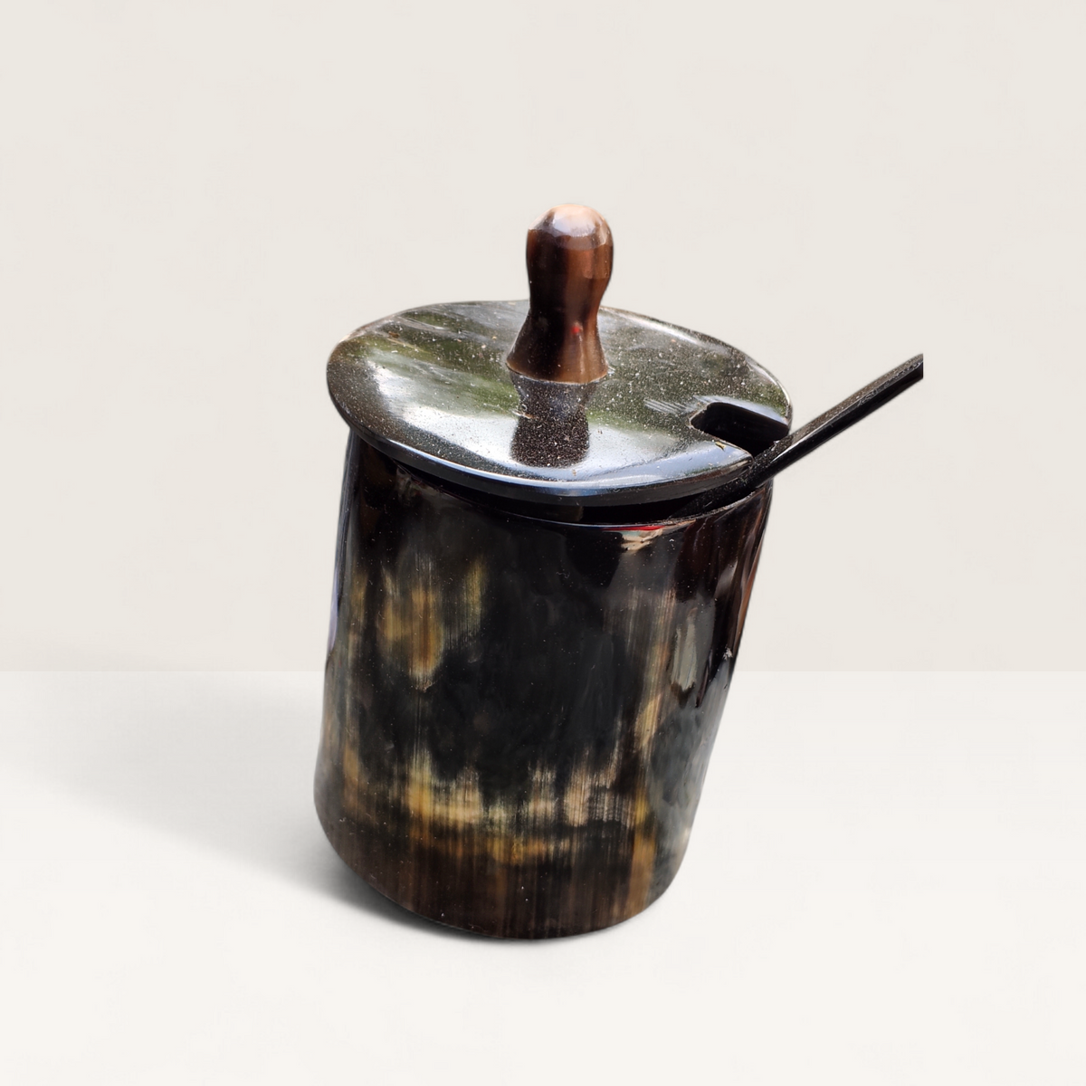 Handcrafted natural dark polished Kenyan cow horn sugar bowl with a dark lid, spoon notch, and horn spoon, made in Kenya.