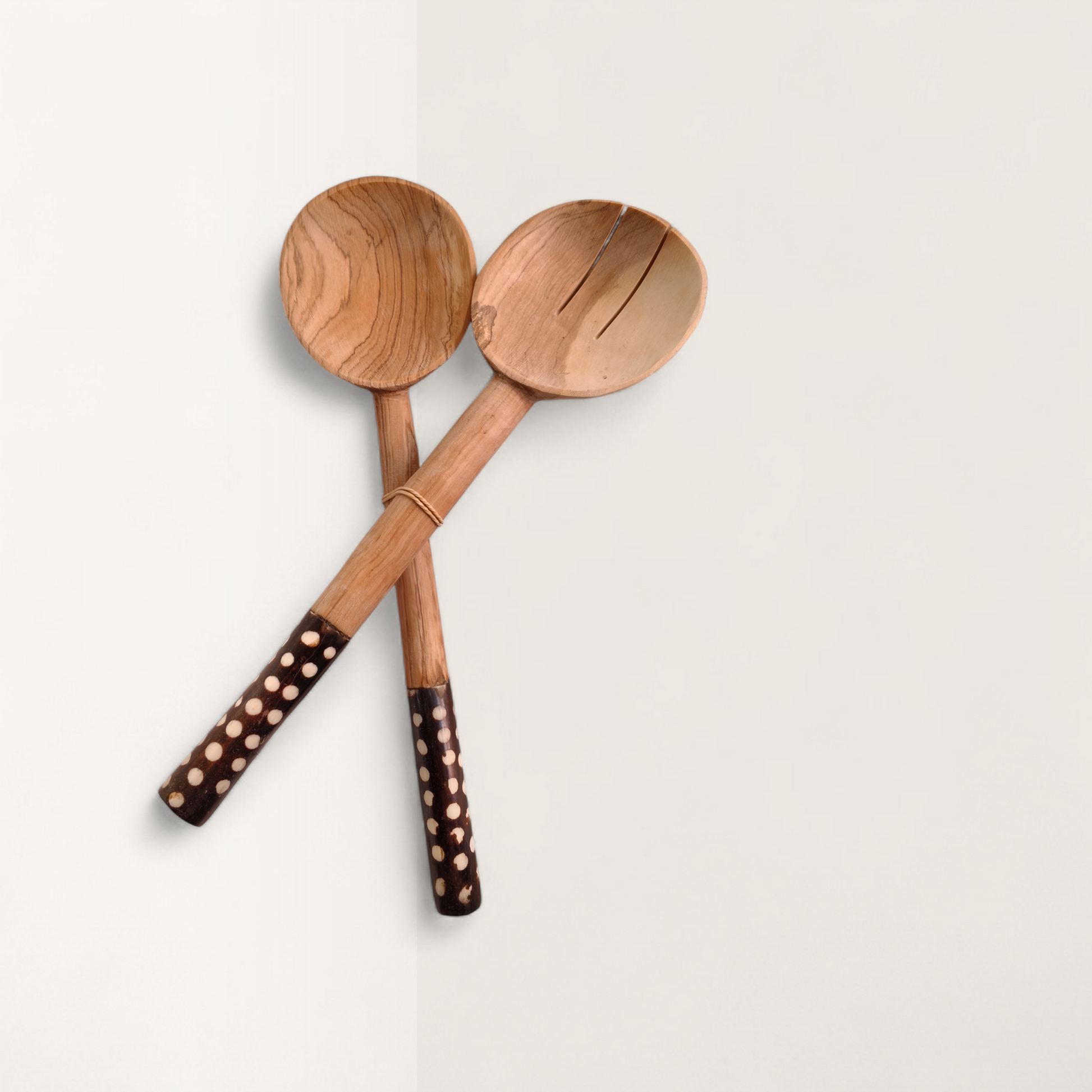 Handcrafted 2-piece Kenyan olive wood salad serving spoons with dark polka dot batik bone handles, made in Ukambani Kenya.