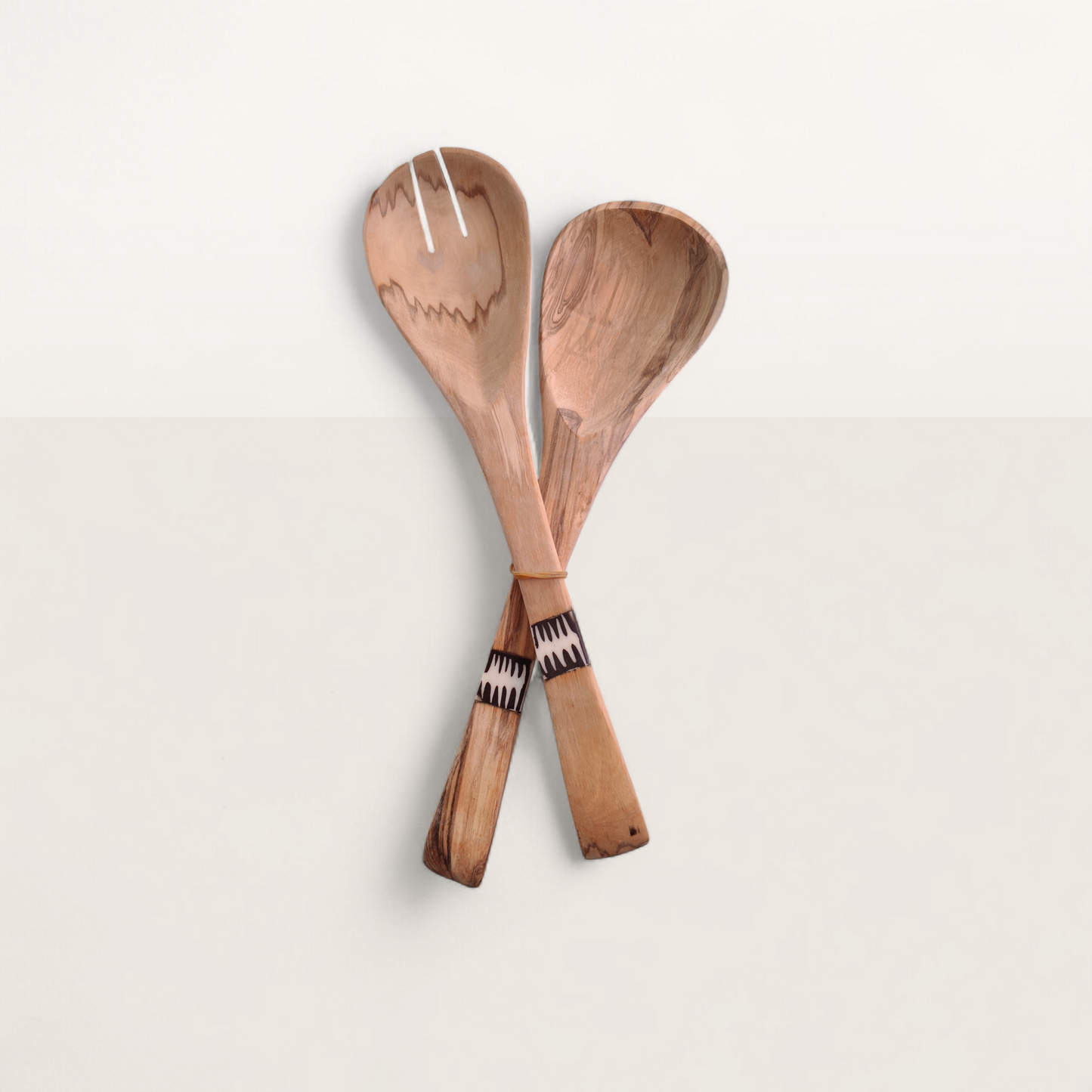 Two wooden spoons with a patterned handle on a light background