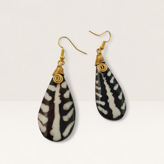 Pair of handcrafted Kenyan teardrop earrings made of dark brown and white batik bone with gold brass wire-wrapped spirals