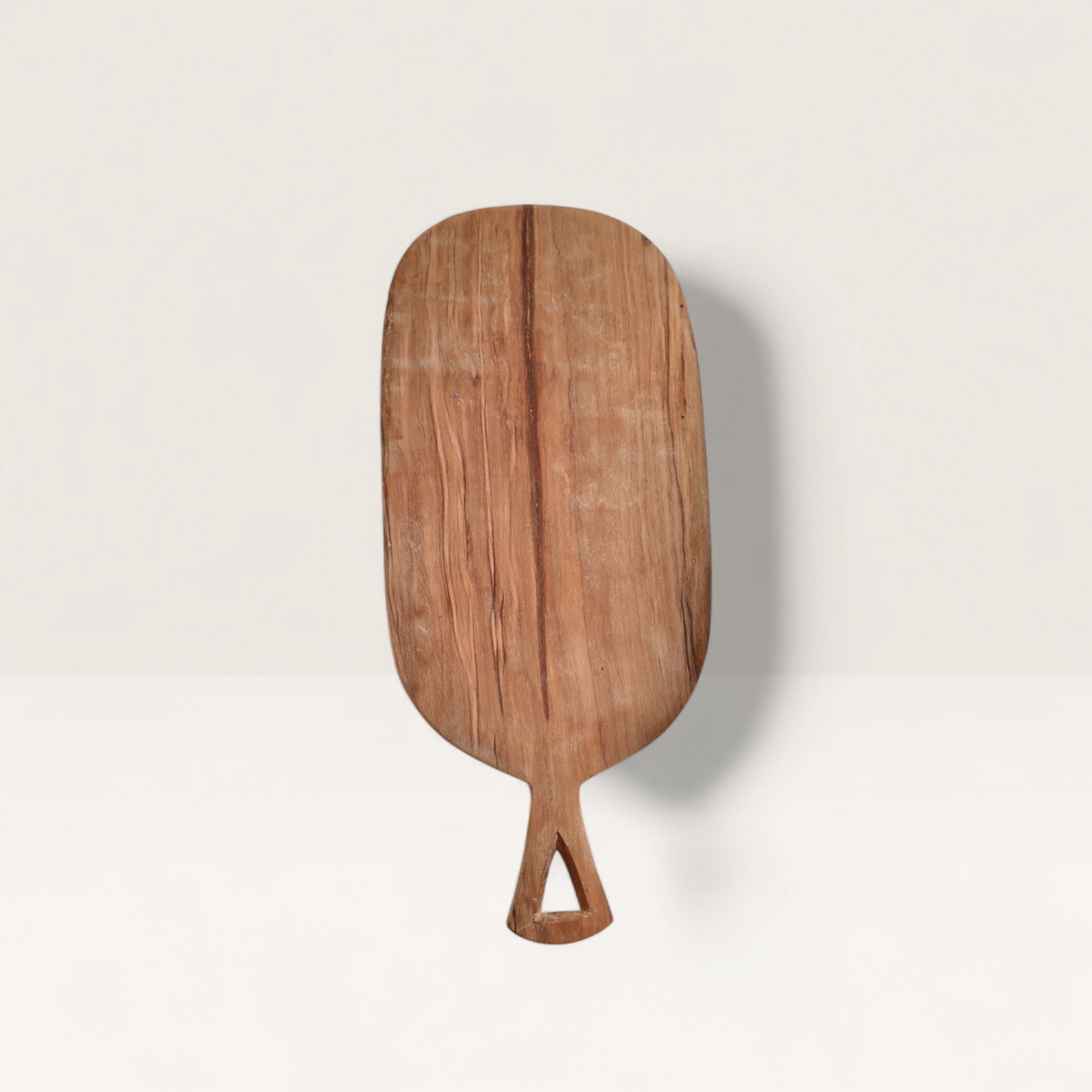 Hand-carved Kenyan olive wood chopping board with a unique triangular handle and rich natural grain, shown on a white background.