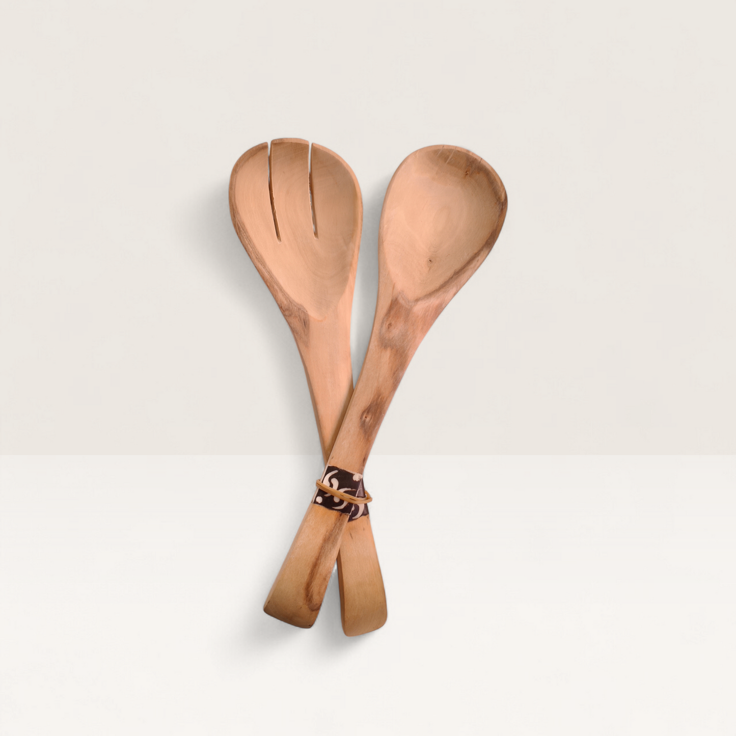 Two wooden spoons with a decorative handle on a light gray background