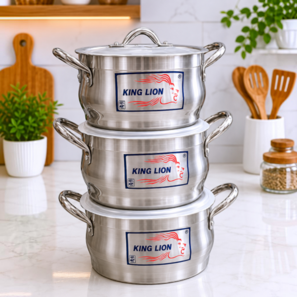 King Lion 3 piece stacked diamond belly polished aluminium casserole sufuria set 3L 4L 5.5L with lids manufactured by Kaluworks on a white marble kitchen counter next to a red product banner