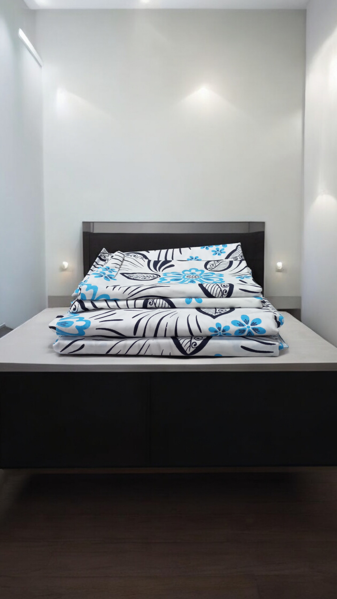 Two flat sheets and two pillowcases in blue and white with an abstract design.
