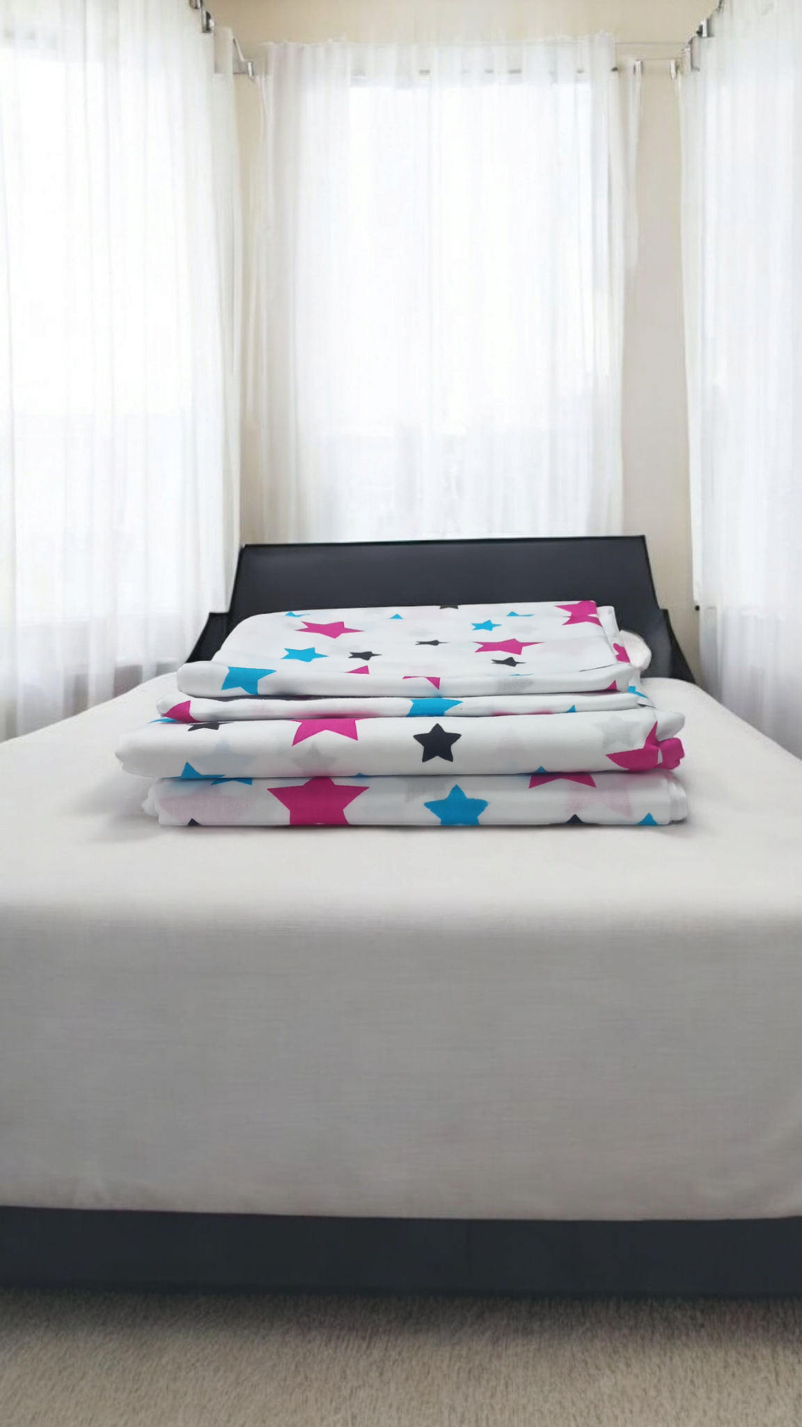 Two flat sheets and two pillowcases with a pink and blue star pattern.

