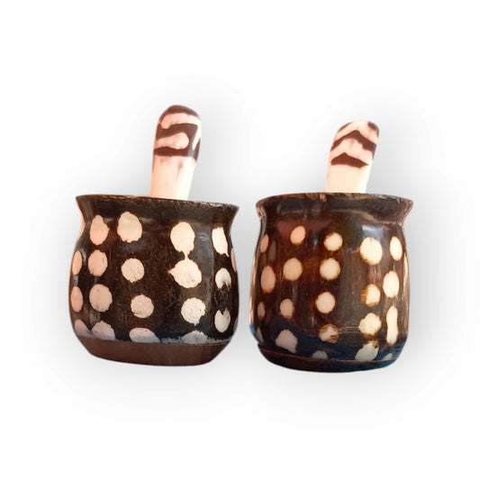 a pair of bone spice pots wiith a wooden base. they have a dotted pattern. 