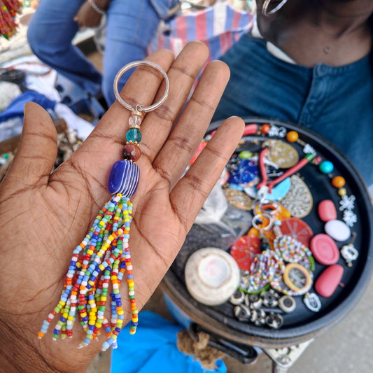 Nualocal handcrafted beaded tassel keychain with multicolored glass seed beads and a blue striped focal bead.