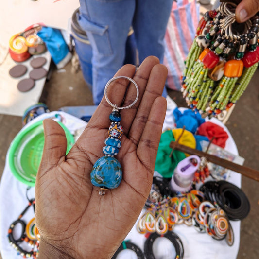 Nualocal handcrafted blue ceramic and resin beaded key holder with a silver split ring held in a palm