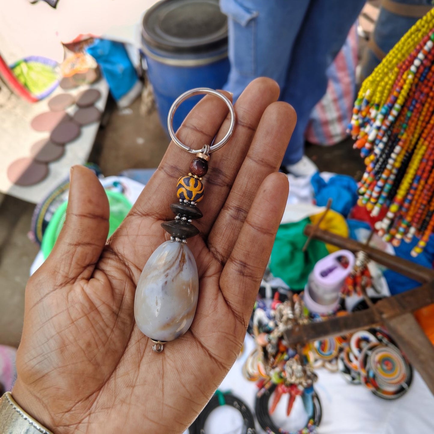 Nualocal handcrafted key holder with a smooth stone pendant, patterned ceramic bead, and dark spacers on a metal ring.