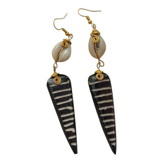 NuaLocal handcrafted dark brown and cream striped batik upcycled bone tapered spear drop earrings with wire-wrapped brass coils and natural cowrie shells, made in Kibera, Nairobi, Kenya.