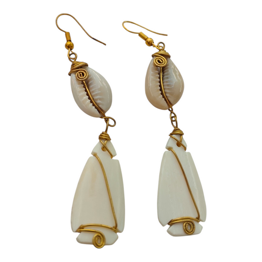 NuaLocal handcrafted off-white upcycled bone arrowhead drop earrings with wire-wrapped brass coils and natural cowrie shells, made in Kibera, Nairobi, Kenya.