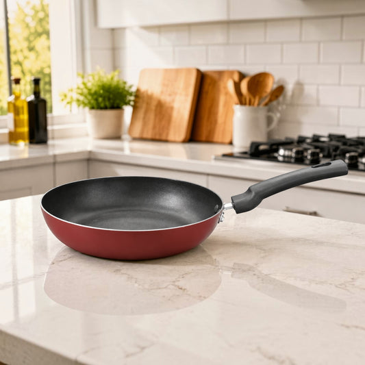 Nualocal Kaluworks maroon non-stick aluminium frypan with a black ergonomic Bakelite handle on a kitchen countertop.