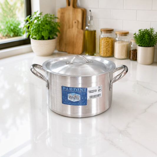 Nualocal Kaluworks Pardini heavy-duty aluminium deep casserole sufuria with lid on a white kitchen countertop.