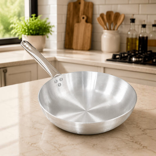 Nualocal Pardini 702 Series polished aluminium frypan with a triple-riveted stainless steel handle on a kitchen counter
