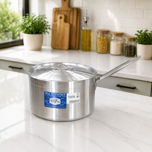 Nualocal Pardini Professional polished aluminium saucepan with lid and long stainless steel handle on a kitchen counter.