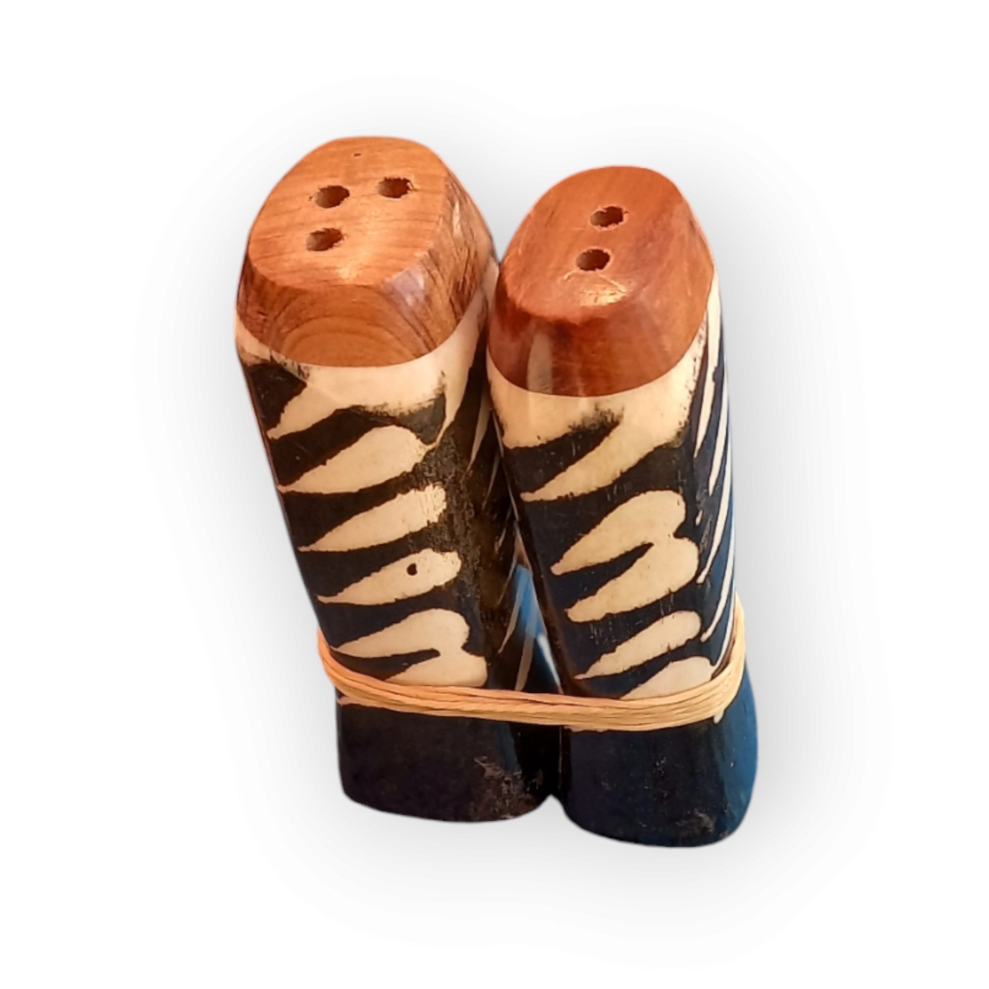 a pair of white and black salt shakers with a wooden base, made of cow bone 