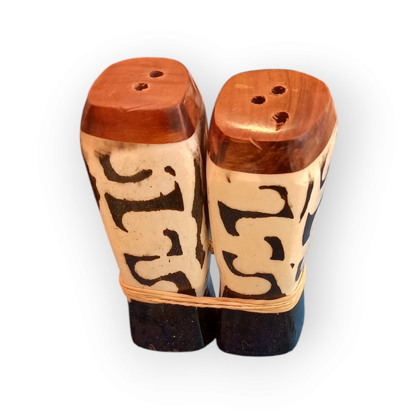 a pair of white and black salt and pepper cow bone shakers with an intricate geometric pattern.  Handmade in Kenya 