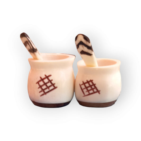 a pair of white spice pots with an intricate geometric pattern an a wooden base. handmade in Kenya 