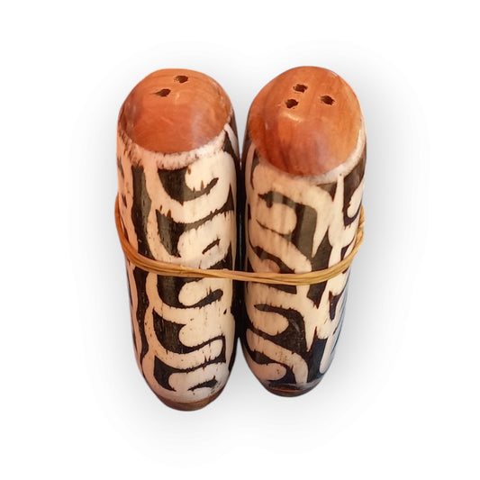 Kenyan handcrafted camel bone salt and pepper shakers set with unique black and white abstract patterns.