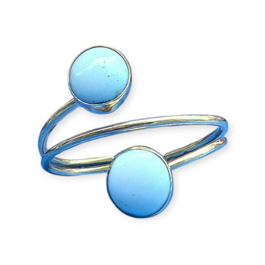 A stylish and adjustable bracelet crafted from brass in Kenya, designed as an open cuff and accented by two beautiful, round white beads.