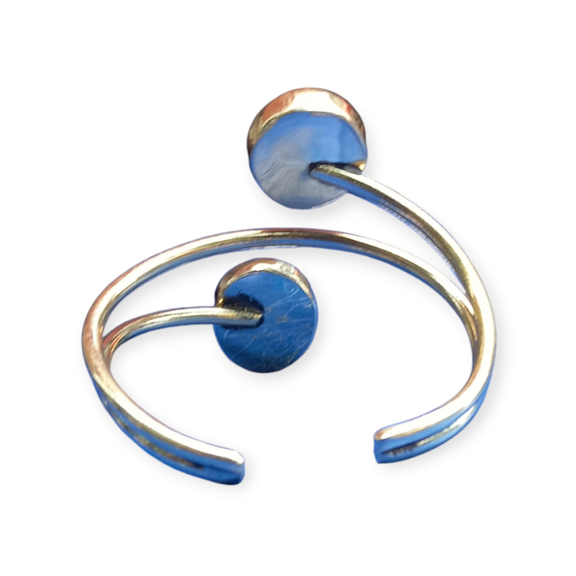 A stylish and adjustable bracelet crafted from brass in Kenya, designed as an open cuff and accented by two beautiful, round white beads.