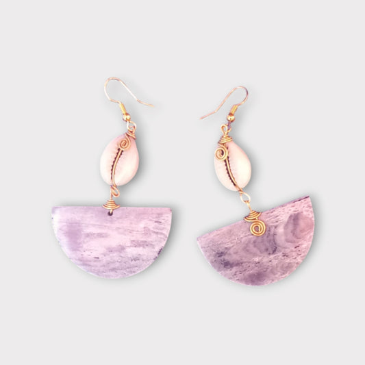 Handcrafted Kenyan earrings featuring a white cowrie shell and a semi-circular bone pendant with subtle patterns.