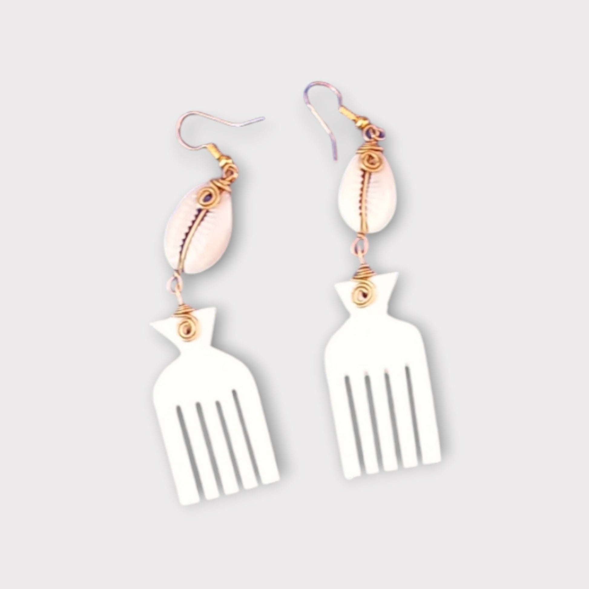 Dangle earrings with a small white cowrie shell connected to a distinctive Afro pick made of bone, crafted in Kenya