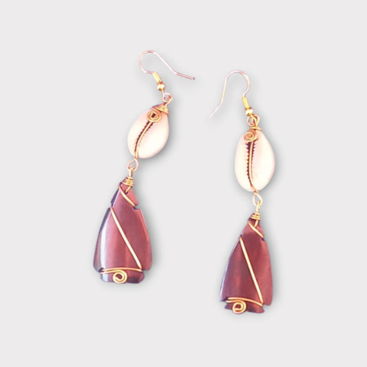 Artisan-crafted earrings from Kenya, showcasing a delicate cowrie shell and a smooth teardrop bone element with detailed gold wire wrapping.
