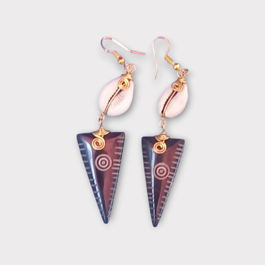 Modern tribal dangle earrings with a small white cowrie shell connected to a carved bone arrowhead, made in Kenya.