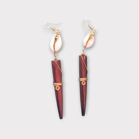 Bold tribal dangle earrings with a small white cowrie shell connected to a striking, spiked bone piece, made in Kenya.
