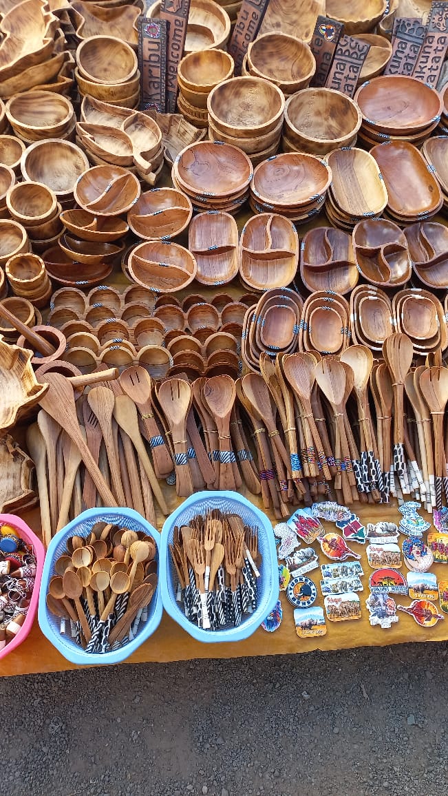 Assortment of carved wooden bowls, serving dishes, and spoons, Kenyan souvenirs, Maasai Market.