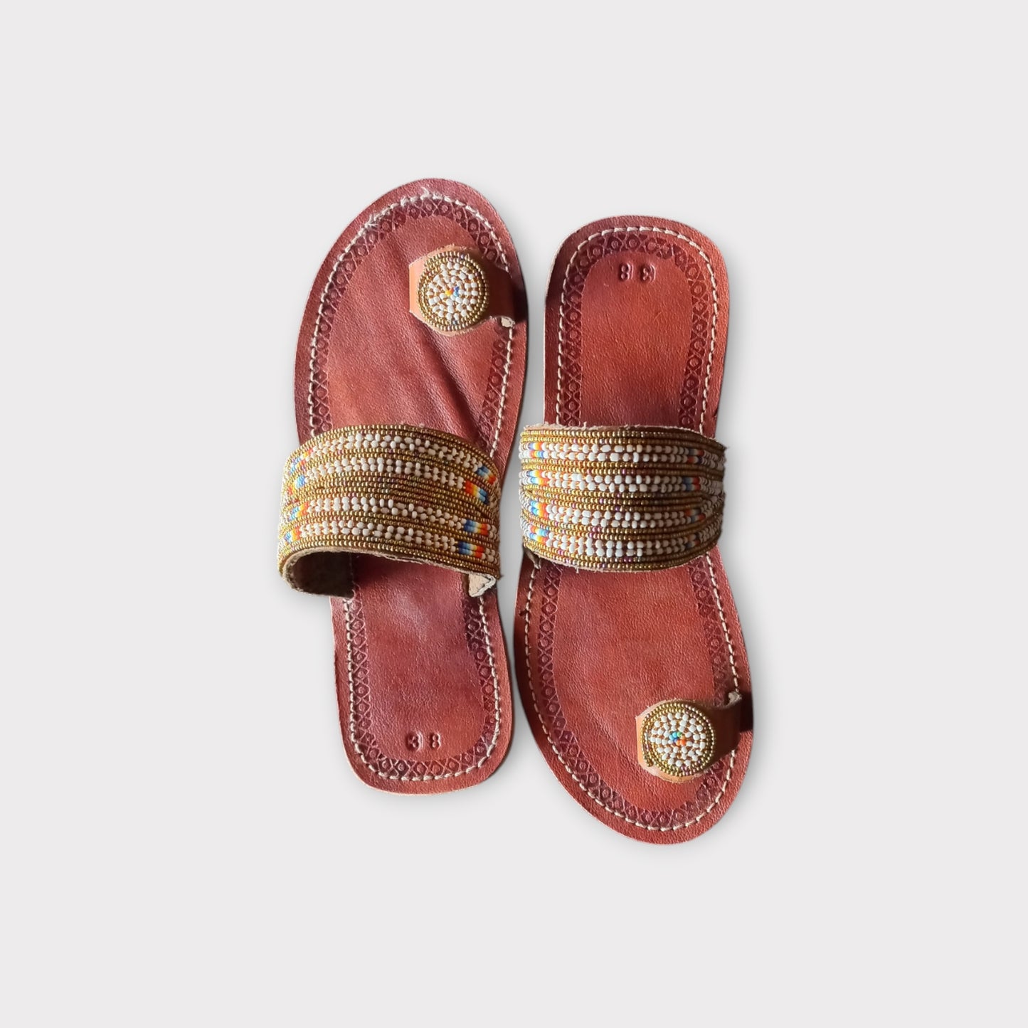 a pair of brown leather beaded sandals 